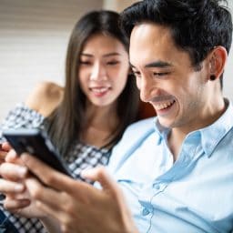 Man with hearing aid looks at phone