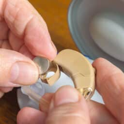 Close up of a woman changing her hearing aid battery.